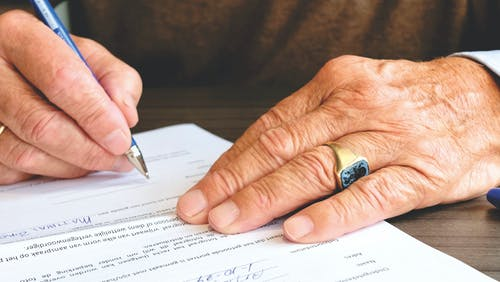 hands signing a document